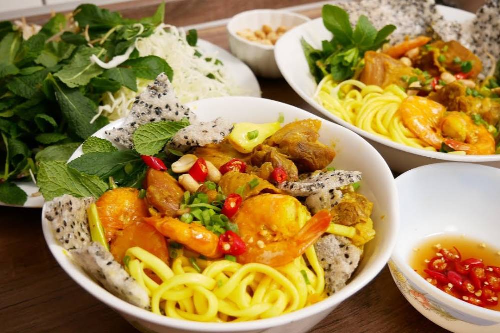 Uma tigela de Mi Quang, uma especialidade de Hoi An, com macarrão colorido atraente