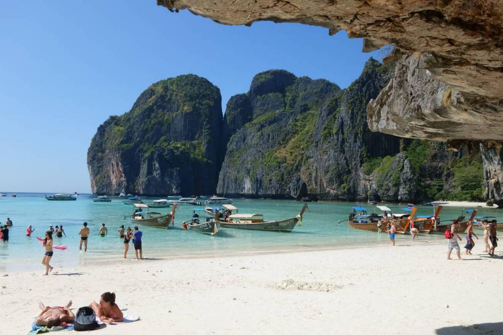 Turistas coçando a cabeça em uma praia em Maya Bay