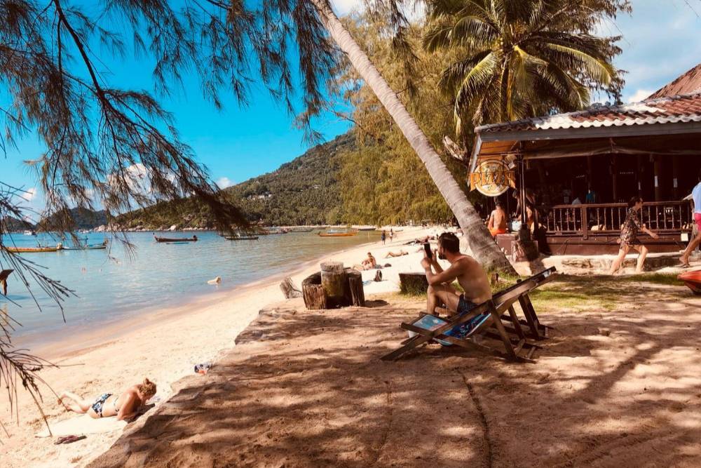 Turistas relaxam na praia do Sairee Cottage Resort, Koh Tao, Tailândia