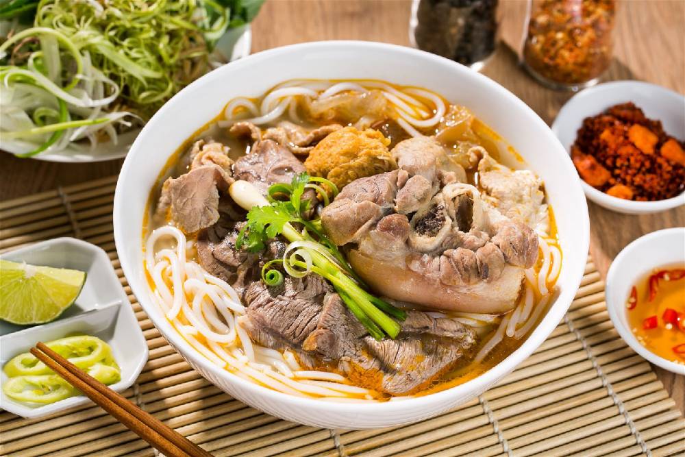 Uma tigela de Bun Bo Hue com cobertura completa